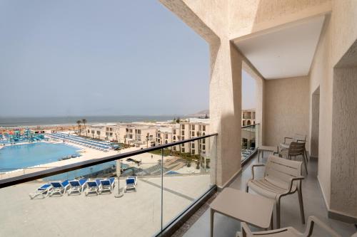 a balcony with chairs and a view of a pool at Pickalbatros Palais Des Roses - Agadir - All Inclusive in Agadir
