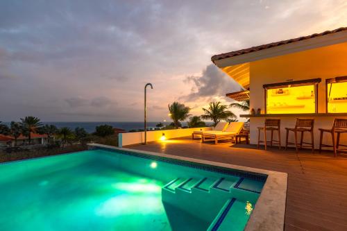 a villa with a swimming pool and a house at Villa Shelu in Willibrordus