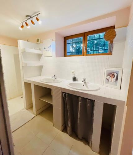 une salle de bain avec deux lavabos et une étagère dans l'établissement Ô fil de l'eau - Gîte en bord de lac, à Saint-Maurice-sur-Loire