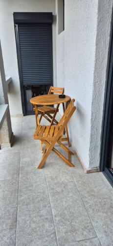 a wooden picnic table sitting next to a building at Lux stan na dan in Novi Sad