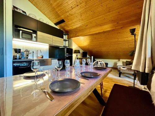 une cuisine avec une table avec des verres à vin dessus dans l'établissement Appartement familial avec piscines et parking, proche centre et skibus - FR-1-624-103, à Samoëns