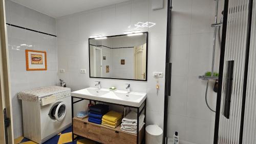 a bathroom with a sink and a washing machine at Mondänes Zimmer nahe Alex in Villenlage in Berlin