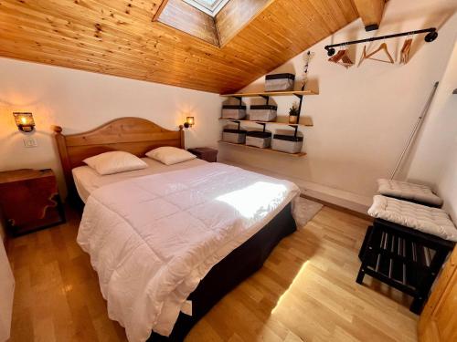 - une chambre avec un grand lit et un plafond en bois dans l'établissement Appartement familial avec piscines et parking, proche centre et skibus - FR-1-624-103, à Samoëns