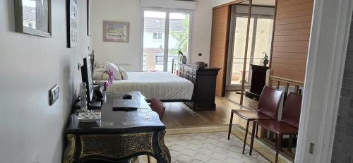 a bedroom with a bed and a table and chairs at Maison design aux portes de Paris in Puteaux