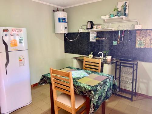 a kitchen with a table and a white refrigerator at Ámbar house apart Iguazú in Puerto Iguazú