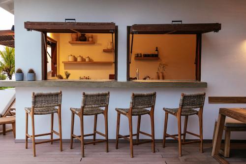 a group of chairs sitting at a bar at Villa Shelu in Willibrordus