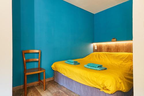- une chambre bleue avec un lit et une chaise dans l'établissement Joyone studio 2 personnes, à Mouthier-Haute-Pierre