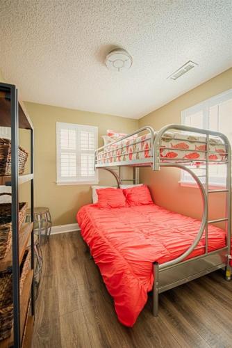 a bedroom with a bunk bed with red sheets at Windy Hill Villa 1 - Beach Barnacle in Myrtle Beach