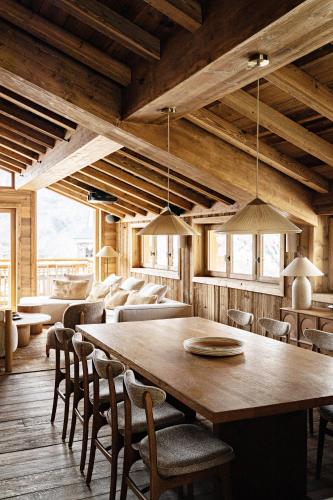 une salle à manger avec une grande table et des chaises en bois dans l'établissement Les Chalets de la Source 1 - Luxe - Skis aux pieds - 10 personnes, à Saint-Martin-de-Belleville