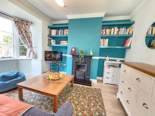 a living room with blue walls and a table at Elegant 3BR Home Near Oxford Centre, Garden, WiFi in Oxford