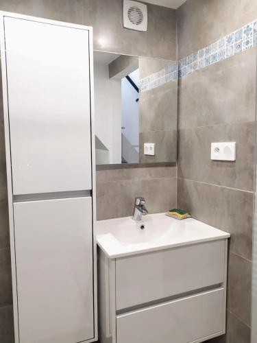 une salle de bain avec un lavabo blanc et un miroir dans l'établissement Cascade Esacapade Duplex, à Nice