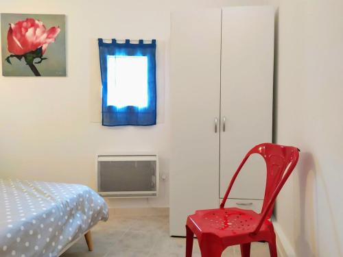 Cette chambre dispose d'une chaise rouge et d'une fenêtre. dans l'établissement Cascade Esacapade Duplex, à Nice
