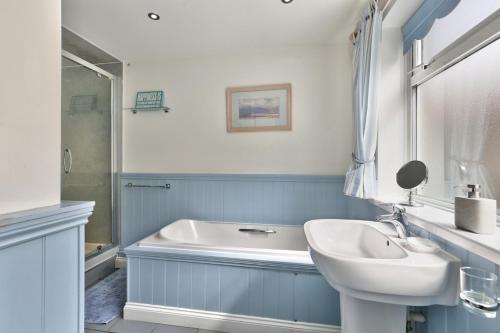 une salle de bains avec lavabo et baignoire dans l'établissement Riverview Cottage - North East Escapes, à Warkworth