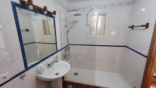 a white bathroom with a sink and a shower at Buenavista in Ayamonte