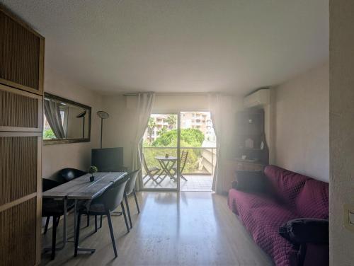 un salon avec une table et un canapé dans l'établissement Fréjus plage T1 bis climatisé- 4 Pers - balcon- côte d'Azur, à Fréjus