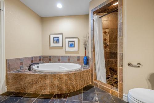 a bathroom with a bath tub and a toilet at CSC4D - Ocean Daze in Kill Devil Hills