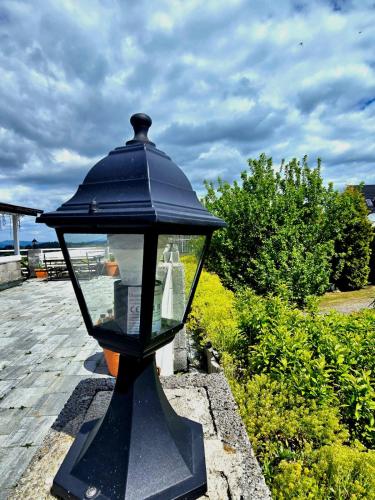 a black lamp sitting on top of a table at Grota zbójnicka apartament i pokoje in Gliczarów
