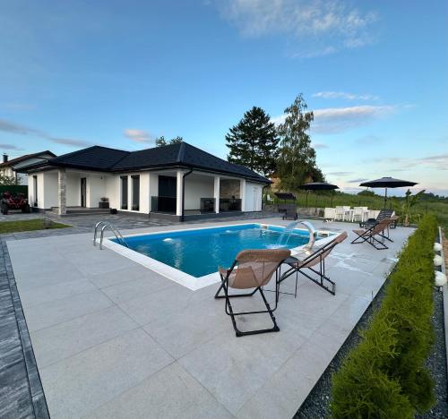 una piscina con 2 sillas junto a una casa en Art Residence, en Tuzla