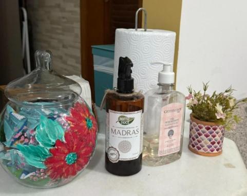 a table with two bottles of alcohol and a candle at Casa Jardim in Miguel Pereira