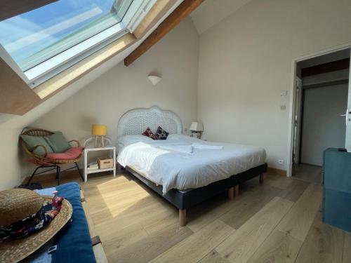 une chambre avec un lit, une fenêtre et une chaise dans l'établissement Ecume - Wifi - Parking - 4personnes, à Carnac