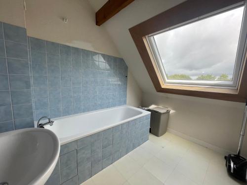 une salle de bain avec une baignoire et une fenêtre dans l'établissement Ecume - Wifi - Parking - 4personnes, à Carnac