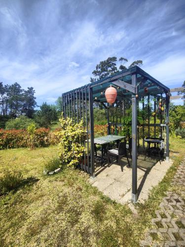 a gazebo with a picnic table and a lamp at O Gato do Campo in Viana do Castelo