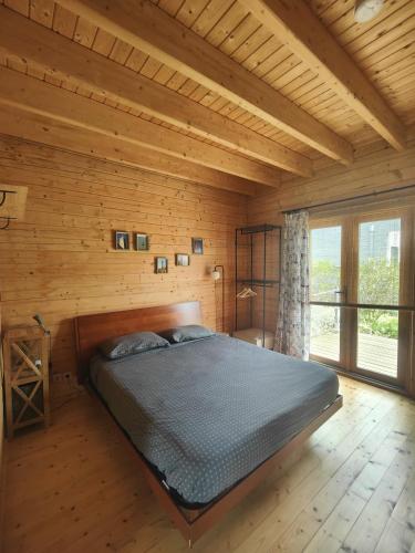 a bedroom with a bed in a wooden room at O Gato do Campo in Viana do Castelo