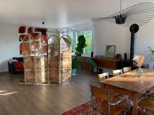 un salon avec une table et un piano dans l'établissement La villa du Moulin, à Aujac