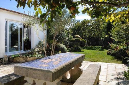 un banc en pierre installé au milieu d'un jardin dans l'établissement 461 Le Bois Family home, Spa, au Bois-Plage-en-Ré