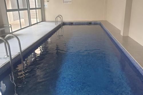 una piscina con agua azul en un edificio en Apartamento de Lujo Cerca de la Playa EL CAMPELLO, en El Campello