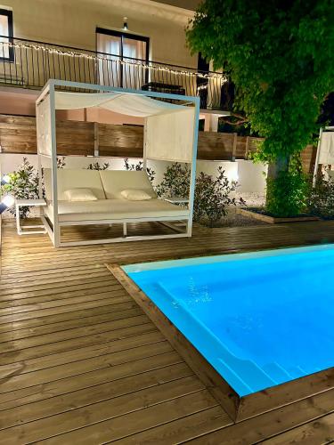- un lit sur une terrasse à côté d'une piscine dans l'établissement Appart 'COSY avec Piscine Chauffée Privée, à Salon-de-Provence
