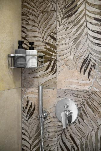 a bathroom with a shower with a design on the wall at PAVEL apartments near airport in Artemida