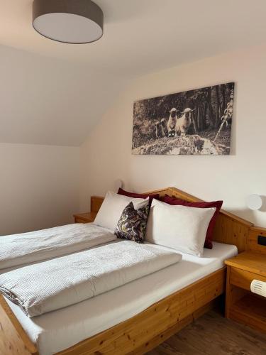 a bedroom with a wooden bed and a painting on the wall at Törggelehof Lana in Lana