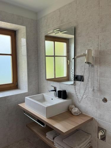 a bathroom with a white sink and a mirror at Törggelehof Lana in Lana