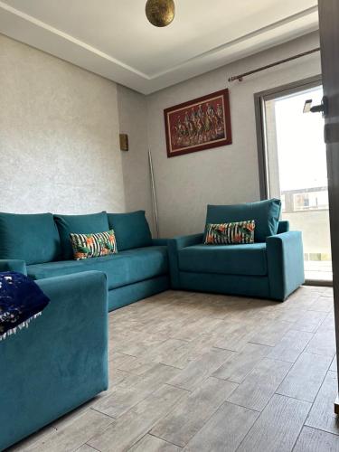 a living room with a blue couch in a room at Marbella beach el mansouria in Mansouria