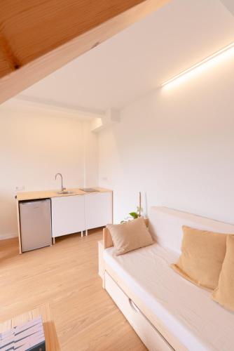 a living room with a white couch and a sink at UMI surf yoga house Doniños beach in Ferrol