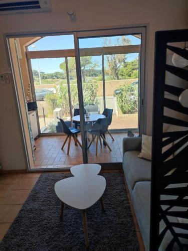 un salon avec un canapé, une table et des chaises dans l'établissement Studio Presqu'ile du Brusc - Gaou, à Six-Fours-les-Plages