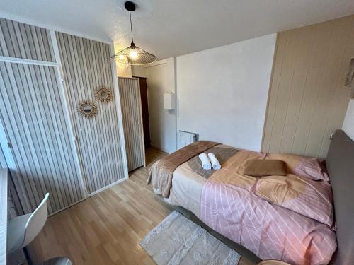 une chambre avec un lit avec une couverture rose dans l'établissement Le Cosy de Bellevue, à Caen