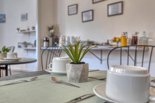 uma mesa com placas e uma planta com vasos em Hotel Borsalino no Porto
