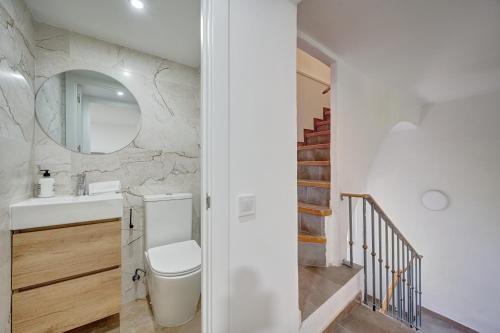 a bathroom with a toilet and a sink and a staircase at La Pequeña Gran Casa by Clabao in Viana