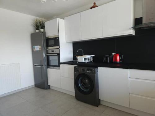 une cuisine avec un lave-linge et un réfrigérateur dans l'établissement Antibes le Vauban grand 2 pièces parking, à Antibes