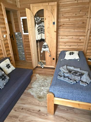 a room with two beds in a wooden cabin at Grota zbójnicka apartament i pokoje in Gliczarów