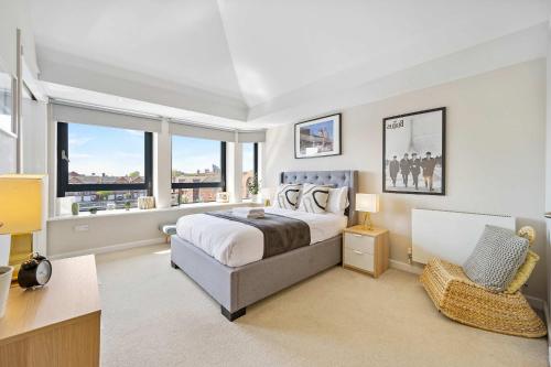 a bedroom with a bed and a desk and windows at Waterfront Penthouse with Balcony & Parking in Liverpool