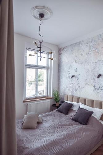 a bedroom with a large bed and a window at Apartament Glamour in Kwidzyn