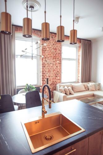 a kitchen with a sink and a living room at Apartament Glamour in Kwidzyn