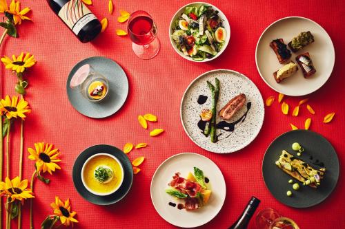 a red table topped with plates of food and drinks at Hotel Indigo Tokyo Shibuya in Tokyo