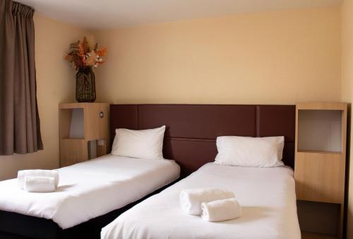 two beds sitting next to each other in a room at Hôtel Les Genêts Bayonne in Bayonne