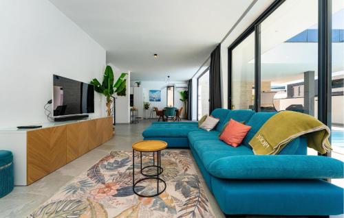 a living room with a blue couch and a tv at Villa Solea in Dračan