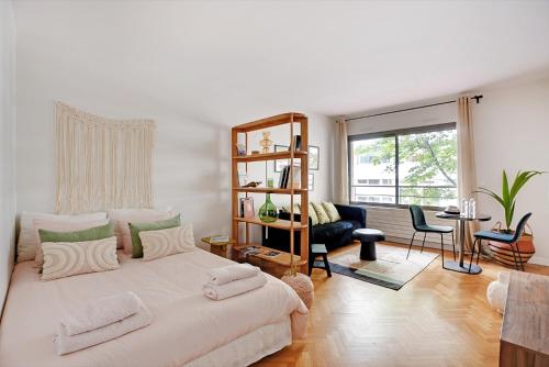 - une chambre blanche avec un grand lit et un salon dans l'établissement Charmant studio au cœur de Levallois-Perret, à Neuilly-sur-Seine