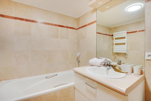 une salle de bain avec un lavabo et une baignoire dans l'établissement Charmant studio au cœur de Levallois-Perret, à Neuilly-sur-Seine